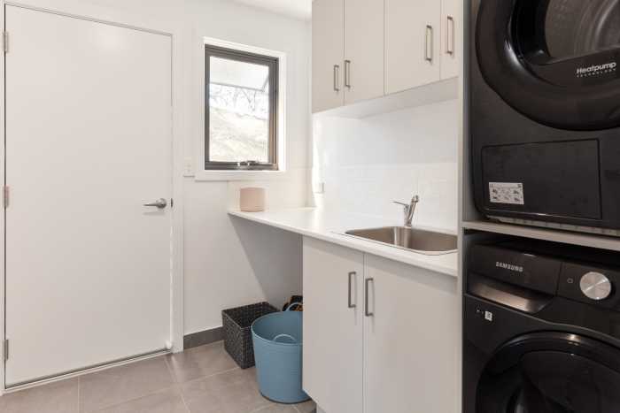 Compact Laundry with Stacked Black Appliances