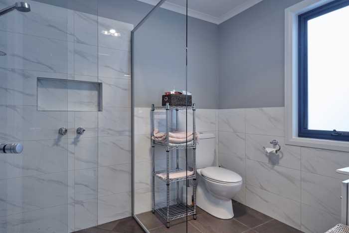 Blue and White Bathroom with Marble Tiled Shower Niche