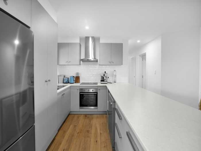 Compact Kitchen with Grey Cabinetry and Timber Floors